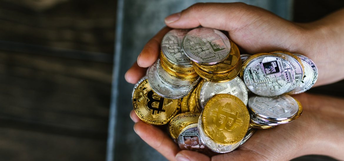 person holding gold and silver coins